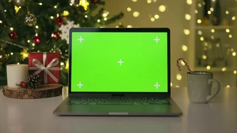 Laptop with green screen. Computer with chroma key on table, burning candle a Stock Footage 220951359
