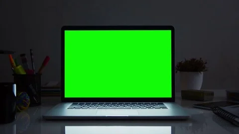 Laptop with green screen. Dark office. Dolly in. Stock Footage