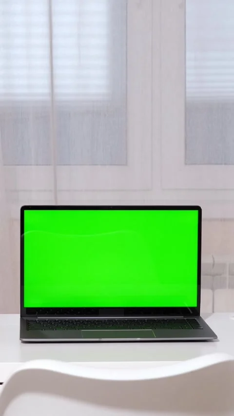 Laptop with green screen mockup on a white table in a home office setting Stock Footage 342944707