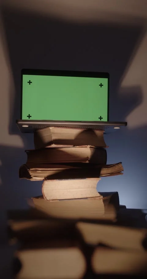 Laptop with green screen over stack of old books. Vídeos de archivo 335633879
