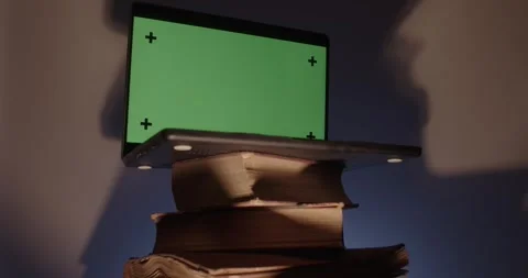 Laptop with green screen over stack of old books. Stock Footage 335633923