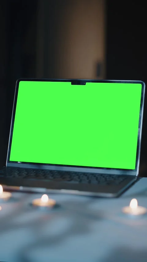 Laptop with green screen on table and candles Video stock 316824130