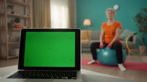 A laptop with a green screen on a table on a blurred background in the living Stock Footage 245185885