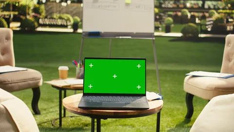 Laptop green screen on table in clean empty rooftop office terrace Stockfoto's