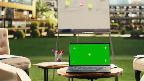 Laptop green screen on table in clean empty rooftop office terrace Stockfoto's
