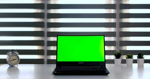 Laptop with green screen on white table in front of roller blind. Dolly in Stock Footage 148157196