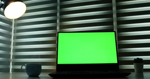 Laptop with green screen on white table in front of roller blind. With Coffee Stock Footage 148287875