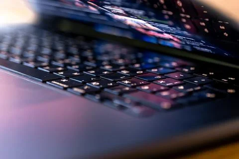 Laptop keyboard close up in colored light. Computer technology detail with .. Stock Photos