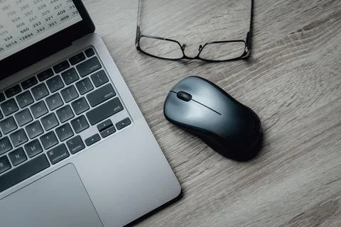 Laptop keyboard, computer mouse and glasses. Working atmosphere on the table Фото