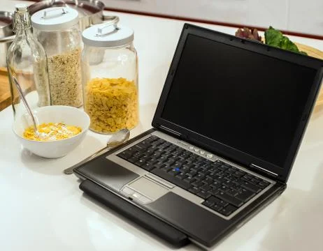 Laptop on the kitchen at the white table Stock Photos