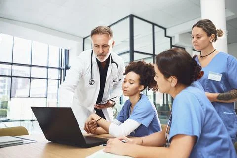 Laptop, learning and training students with doctor in hospital for healthca.. Stockfoto's