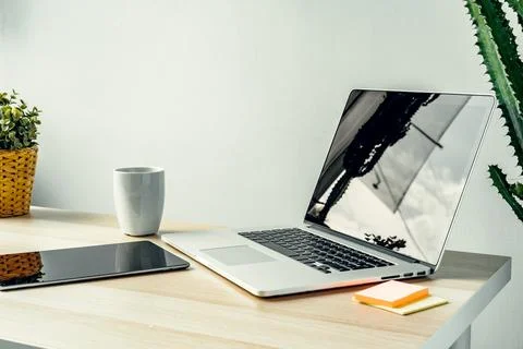 Laptop in a light room on working table with office supplies Stock Photos