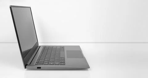 Laptop on a light table. black screen with reflections, Side view of Open lap Stock Photos