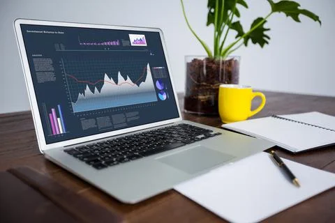 Laptop lying on desk with statistical data on screen Stock Photos