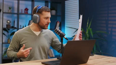 By the laptop. Man with microphone in the studio, conception of podcast. Video stock 297673758