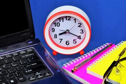 A laptop for the Manager's work, a clock is a symbol of time Stock Photos