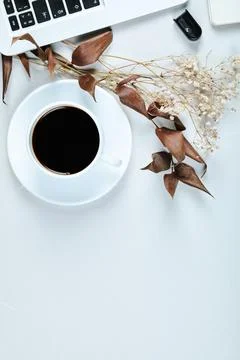 Laptop, mouse and a cup of tea on white desk Stock Photos