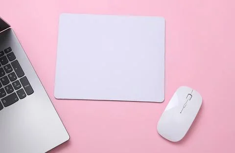 Laptop, mouse, and notepad on pink desk Stock Photos