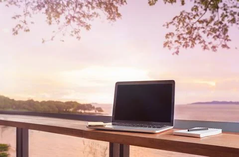 Laptop with note book on the table in the cafe. Freelance work Stock Photos