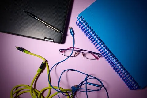 Laptop, notebook, data cables and pen on an office desk. 写真素材