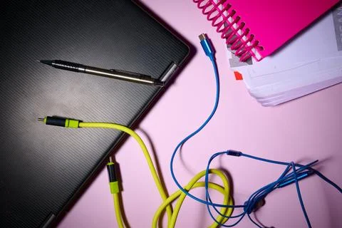 Laptop, notebook, data cables and pen on an office desk. 写真素材