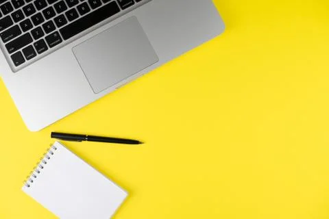 Laptop, notepad planner with black pen on yellow background. Flat lay. Copy s Stock Photos