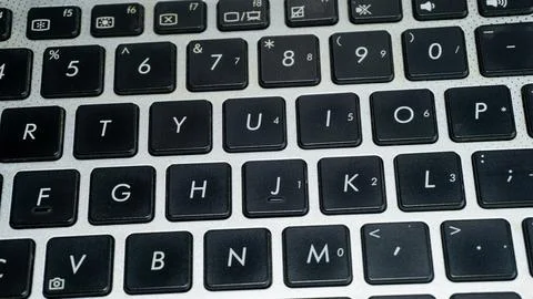 Laptop or computer keyboard with black keys and silver body Stock Photos