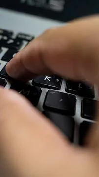 Laptop or computer keyboard with black keys and silver body. With his hands.. Stock Photos