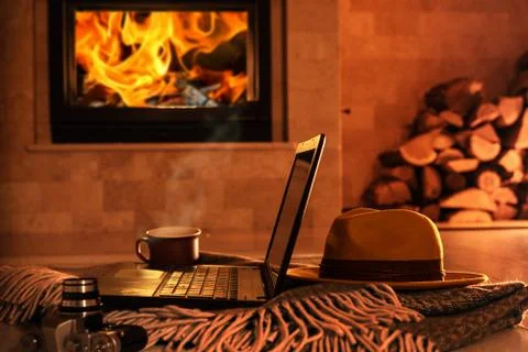 Laptop or notebook, hat, camera, cup on the fireplace background. Foto stock