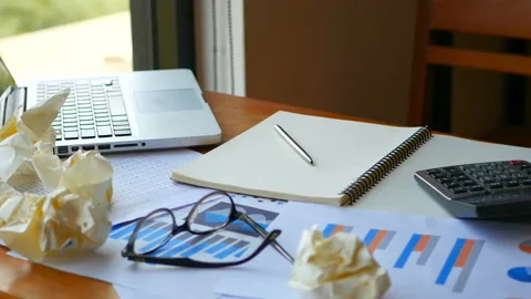 Laptop with paper work as chart and graph account with calculator on table Stock Footage 133874304