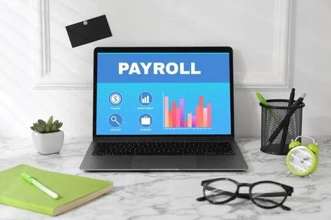 Laptop with payroll data on screen on table Stock Photos