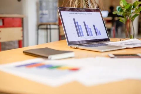 Laptop placed on the table next to the notebook and other office stuff Stock Photos