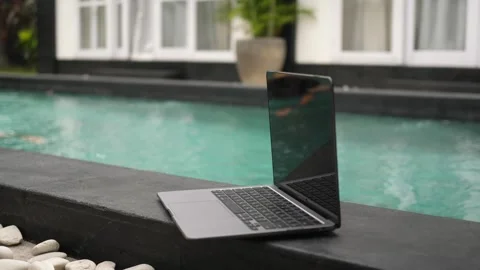Laptop at poolside at sunny day Stock Footage 250013937