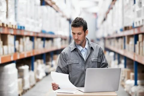 Laptop, reading and documents with man in warehouse for delivery route Stock-Fotos