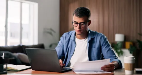Laptop, reading and man with paperwork for remote work, data entry and update Stock Footage 330905210