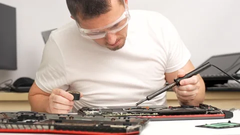 Laptop repair, computer service. Master soldering the chip Stock Footage 239607860