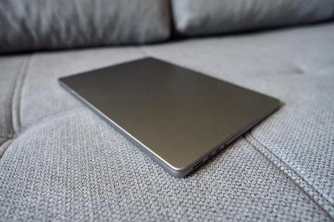 Laptop resting on a sofa Stock Photos