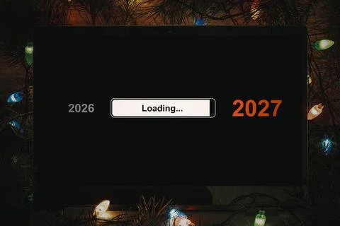 Laptop screen displaying a loading bar between 2026 and 2027, framed by abs.. Stock-Fotos