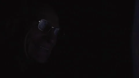 Laptop screen reflects on elderly man glasses in dark room Video stock 242187677