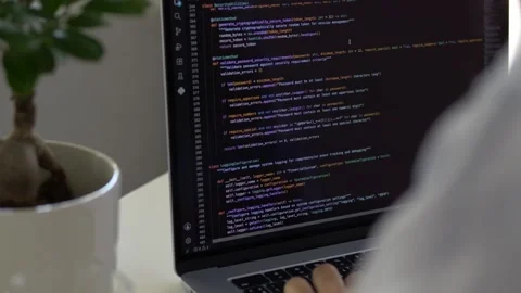 Laptop screen showing programming code while developer works with keyboard Видео 345652481