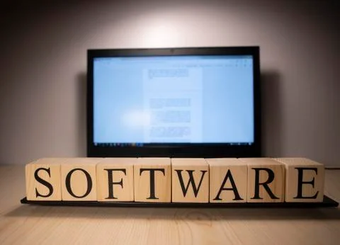 The laptop screen on the table is open. Software word on wooden cubes on lapt Foto stock