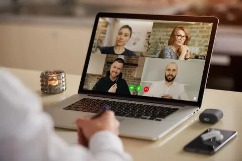 A laptop screen view of the telecommunications application over a man's shoul Stock Photos