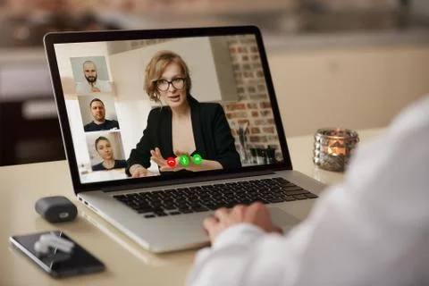 A laptop screen view of the telecommunications application over a man's shoul Stock Photos