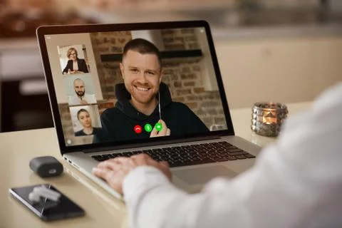 A laptop screen view of the telecommunications application over a man's shoul Stock Photos