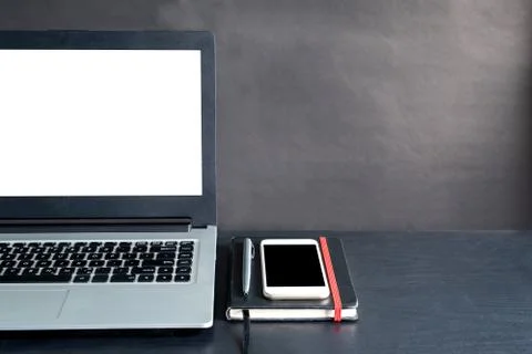 Laptop, smartphone, notebook, pen, on black wooden table with black backgroun Stock Photos