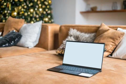 Laptop on sofa with isolated white screen for mockup in Christmas time Stock Photos