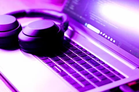  laptop with software code on screen in neon purple light Stockfoto's