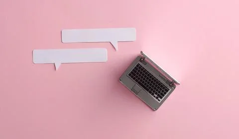 Laptop with speech bubbles on pink background Stock Photos