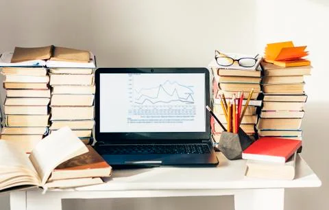 Laptop, stack of books, notebook, pencils in office background for education  Stock Photos