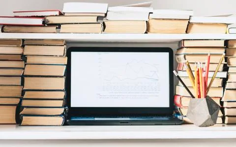 Laptop, stack of books, notebook, pencils in office background for education  Stock Photos